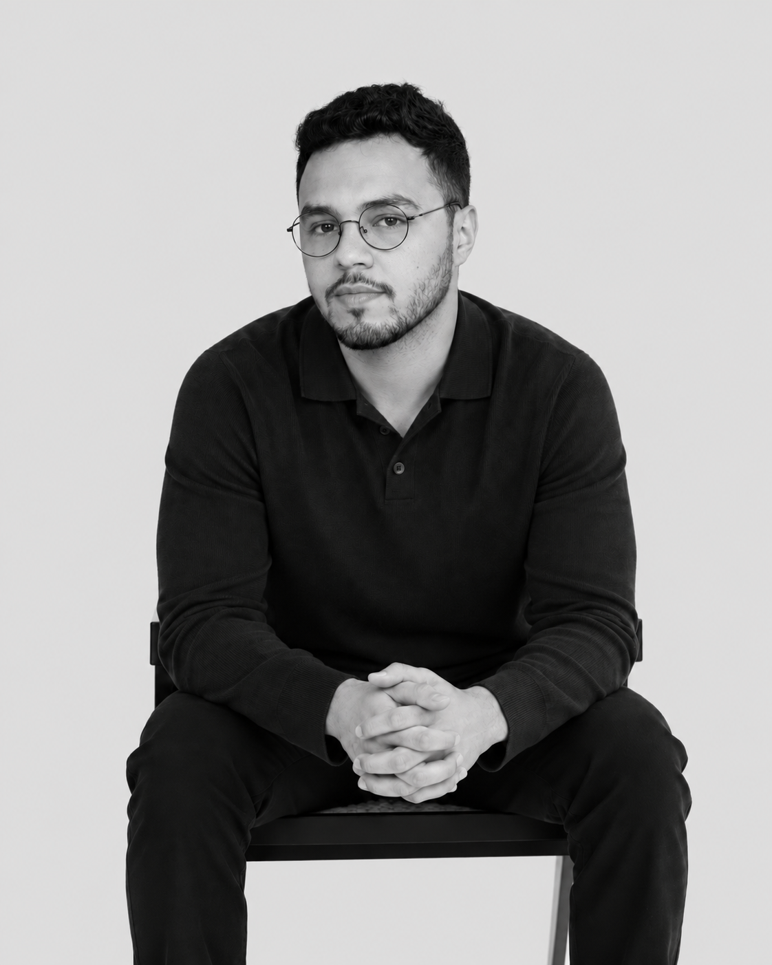 El Mehdi Fateh seated against a minimalist background.
